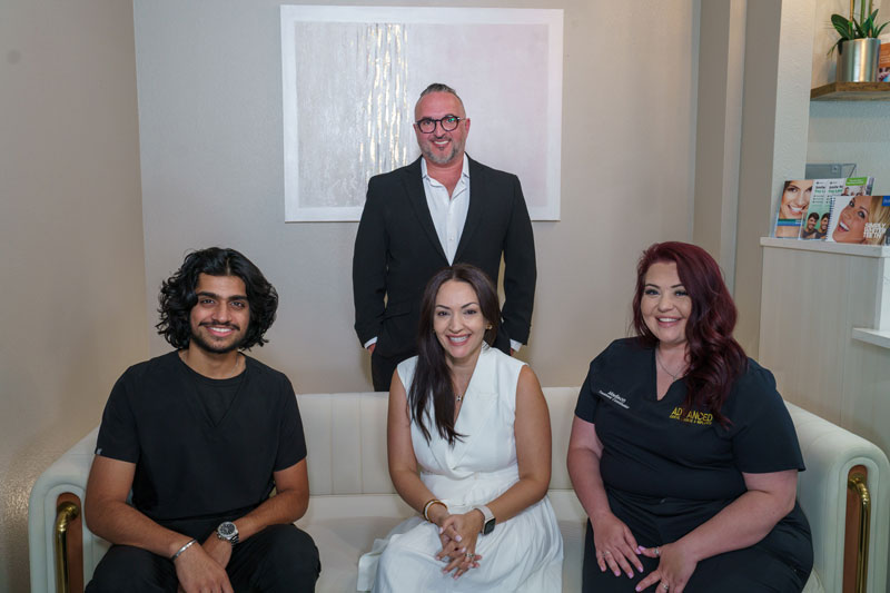the staff at advanced dental lounge 3 sitting on the couch the doctor behind